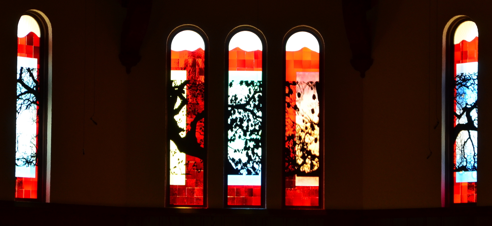 four stained glass windows depicting a tree of life